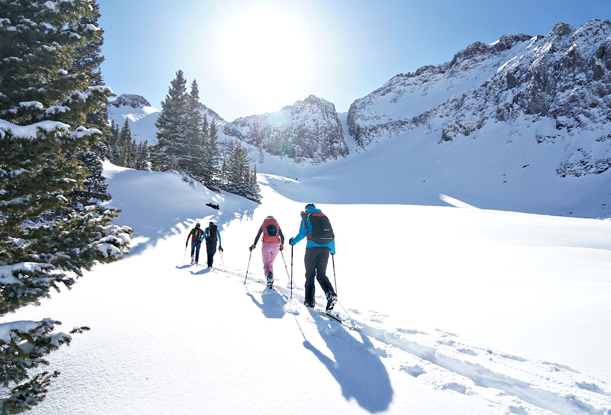 group of skiers walking up mountain