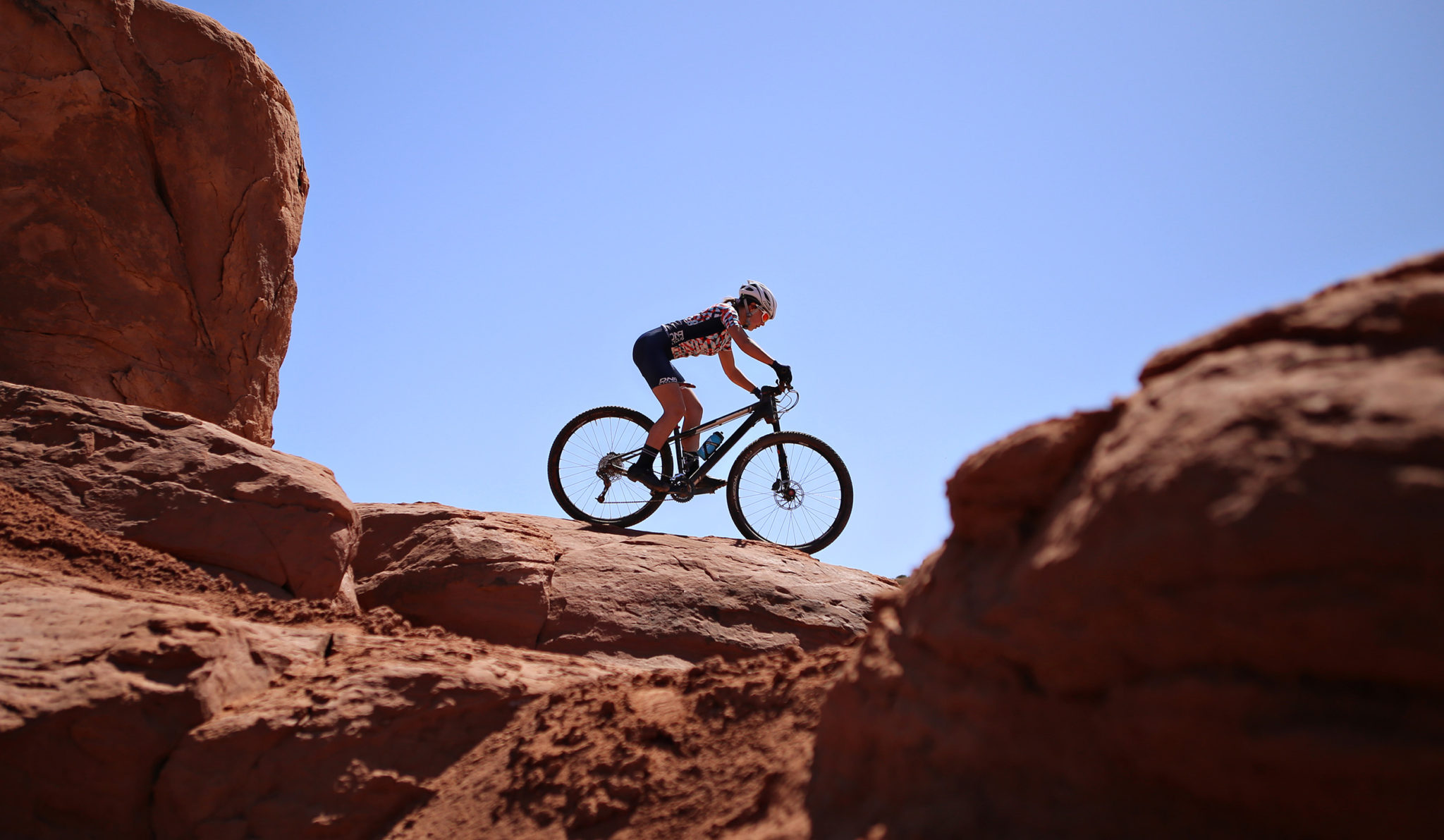 mountain biking on red rock in dna cycling kit