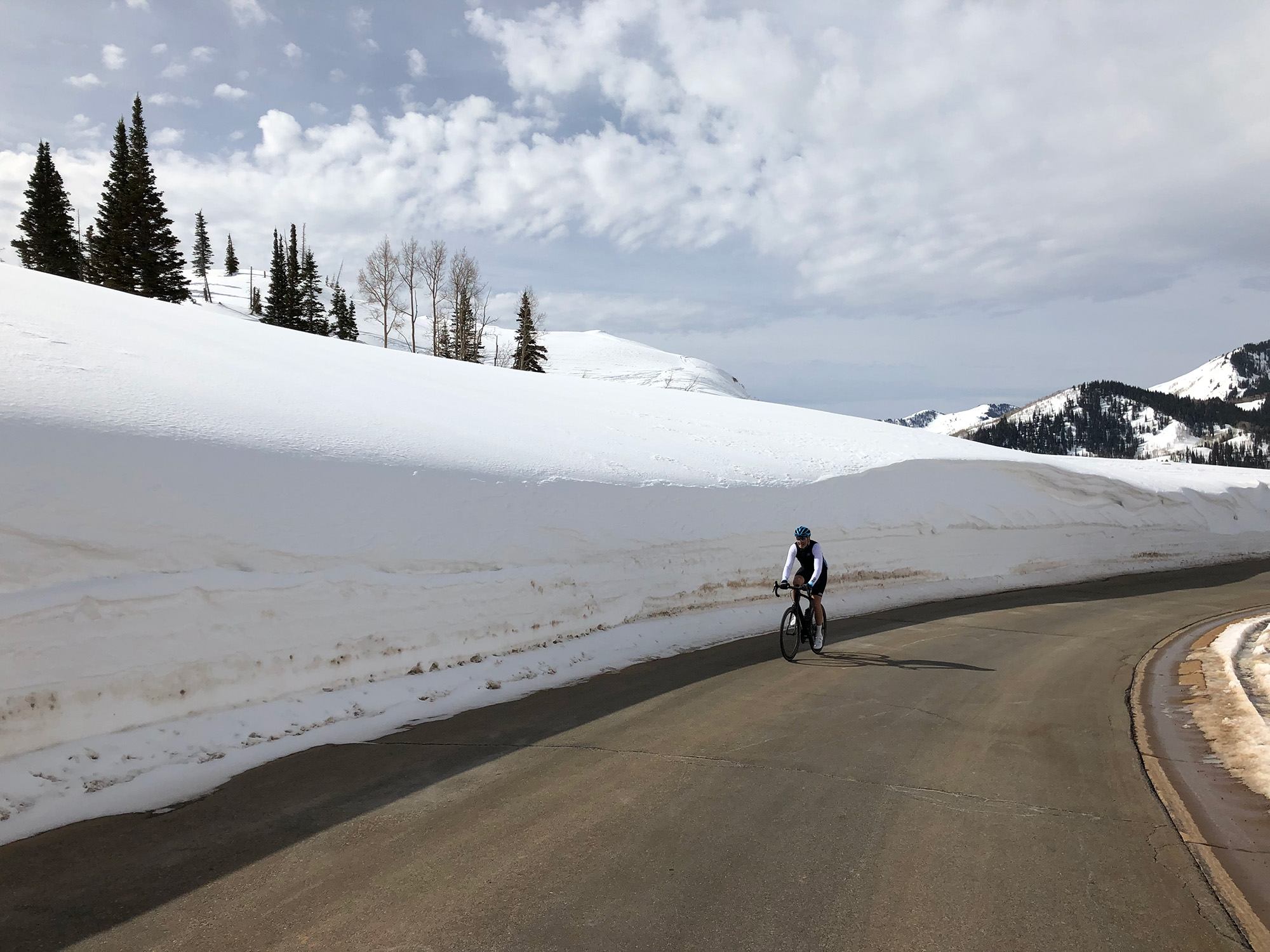 Person riding bike next to large snow pile